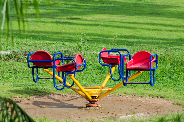 Empty merry-go-round ride in the garden in the morning sunlight