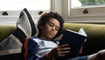 Portrait of 12 year old boy reading a book