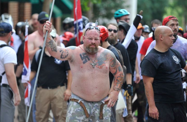 A white supremacist man is seen holding a long pipe during...