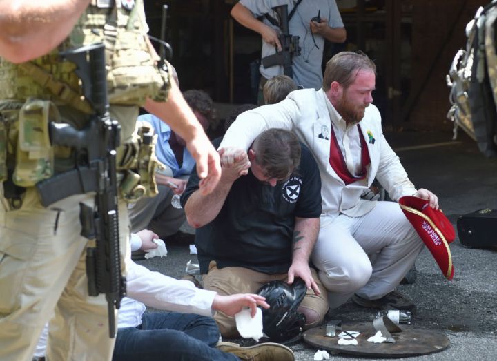 Men are seen sitting on the ground during the State of Emergency.