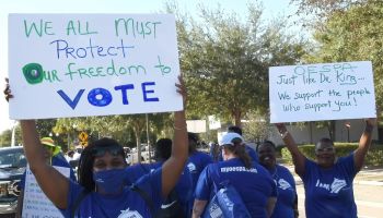 People march with placards in support of voting rights...