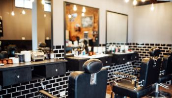 Empty black chairs and mirrors in barber shop