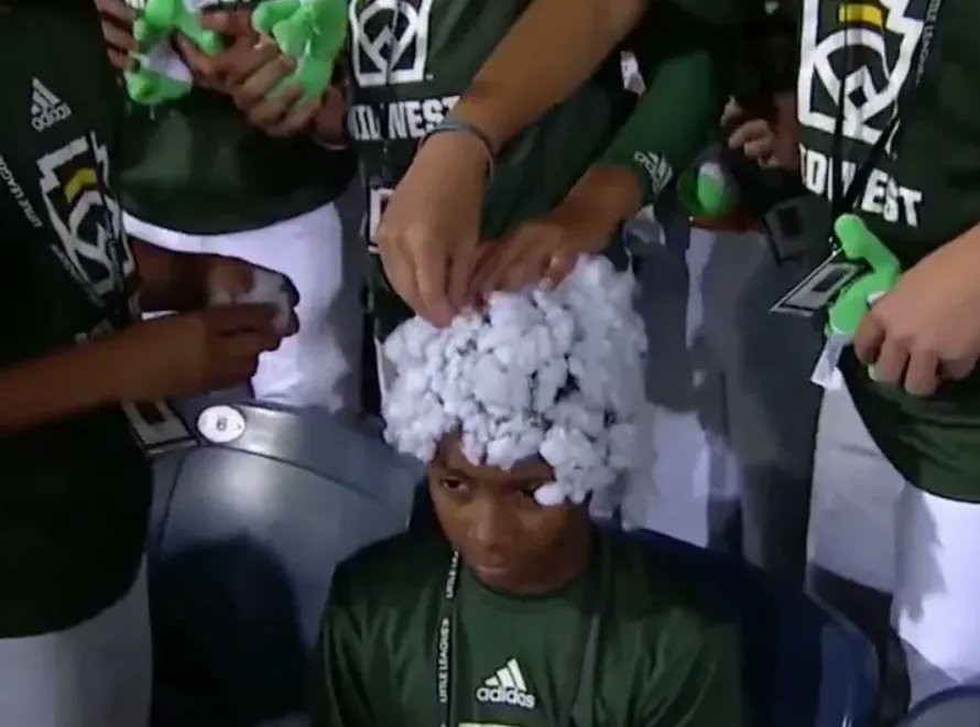 Iowa little league baseball player covered with cotton by white teammates