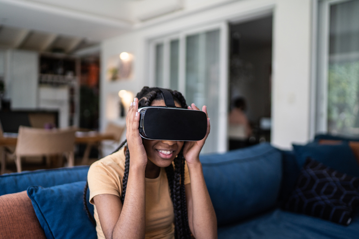 Teenage girl playing using VR glasses at home