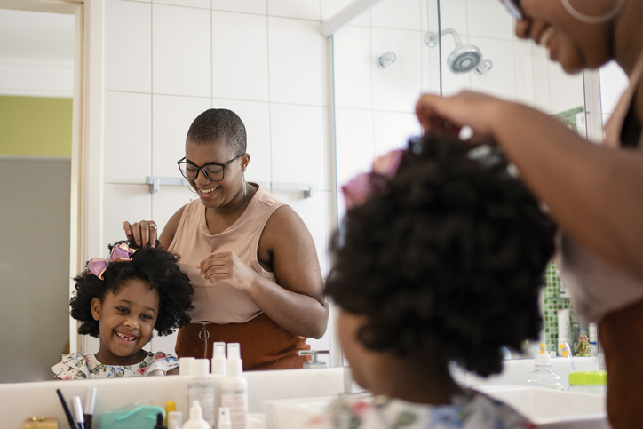 Sisters combing their hair in the bathroom