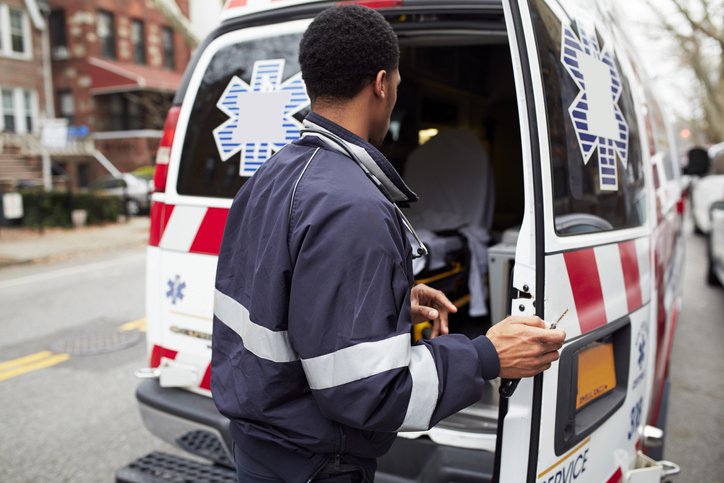 Mixed race paramedic opening ambulance