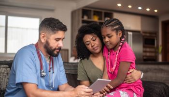 Pediatrician doctor consulting patient at home