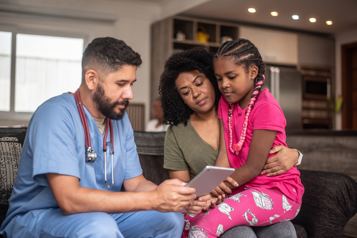 Pediatrician doctor consulting patient at home