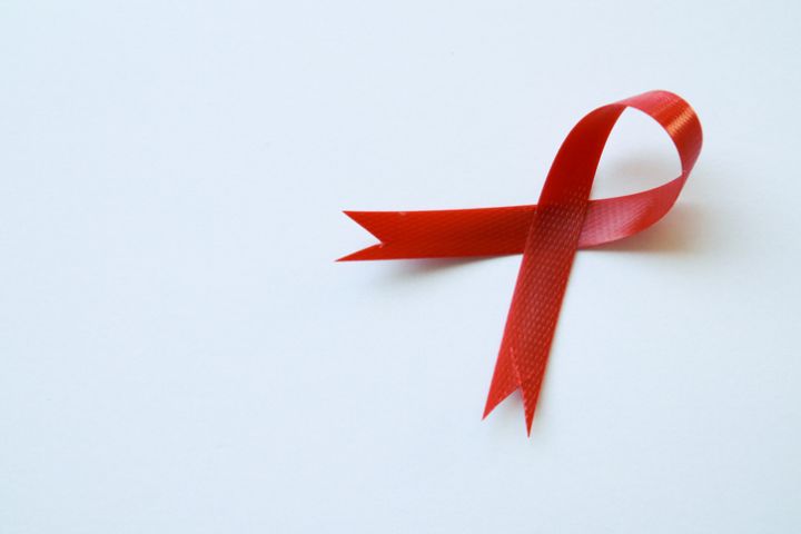 Close-up view of red ribbon on white background showing HIV disease symbol with copy space. Awareness concept. healthcare concept. World AIDS Day.