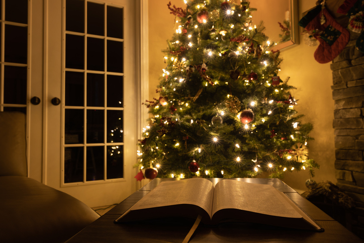 Open bible by Christmas tree