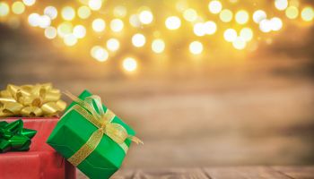 three gift boxes on a wooden background with bokeh, space for text