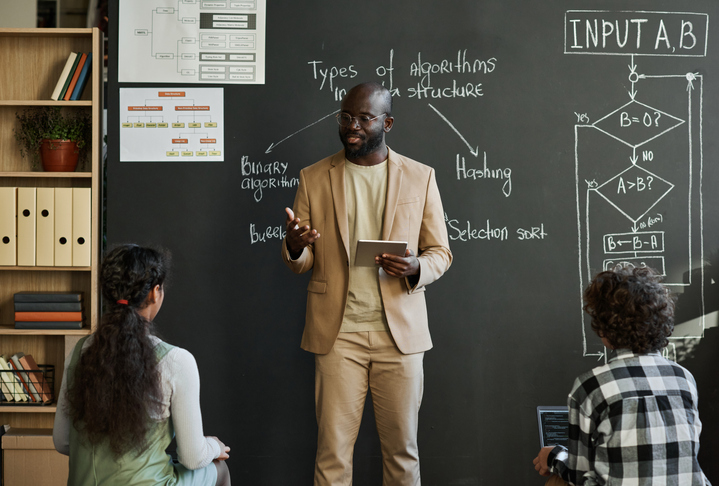 Teacher explaining material to children at lesson