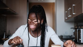 Happy black woman having healthy breakfast in kitchen