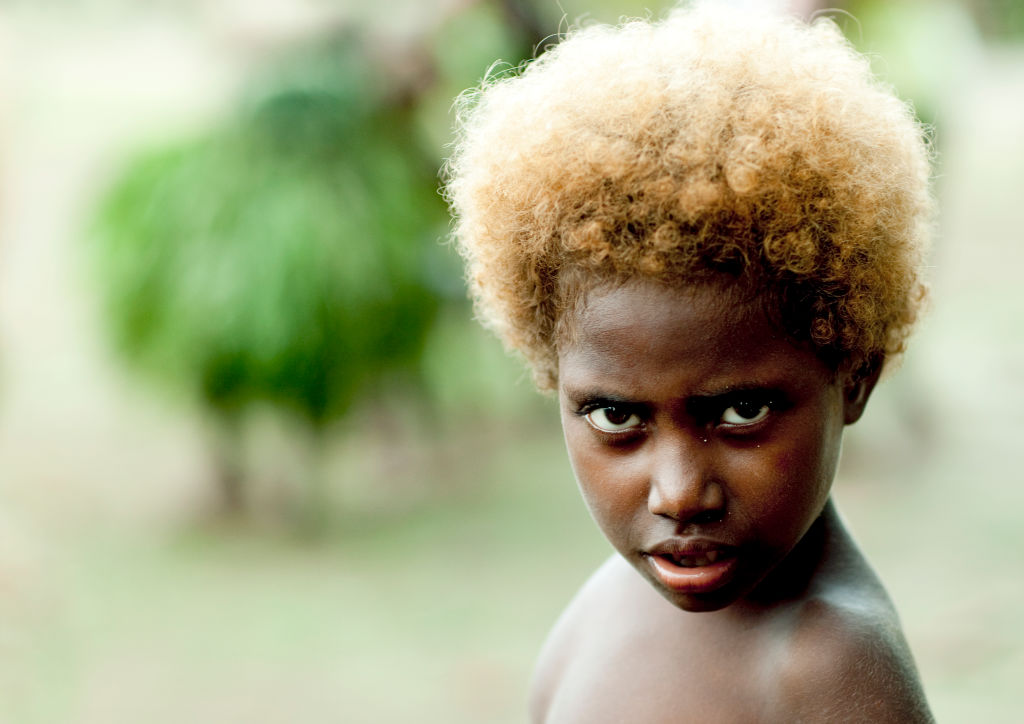 Portrait of a boy with blonde hair looking at camera, New Ireland Province, Langania, Papua New Guinea...
