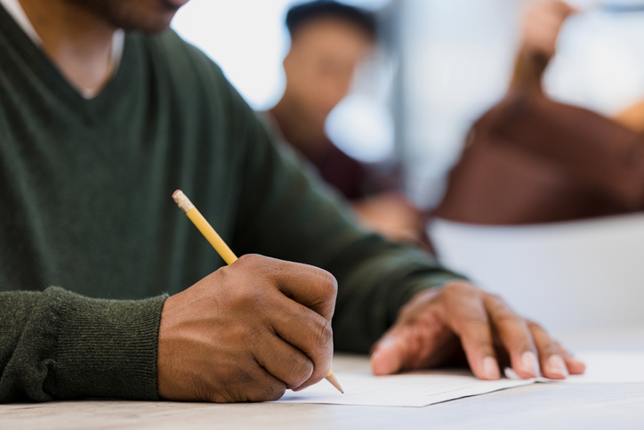 Unrecognizeable man works on classwork