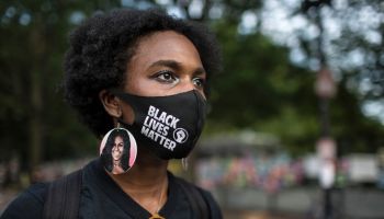 A young woman wearing protective mask with Black Lives...