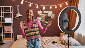 Black teenage girl recording dance video for social media singing