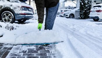 Teenager shoveling snow outdoors on winter day