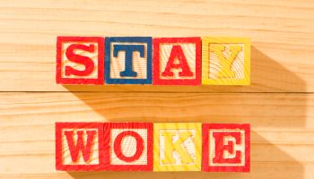 Wooden cubes with the word STAY WOKE on a wooden surface