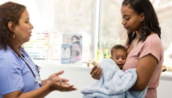 Female doctor explains dosage and side effects to young mom
