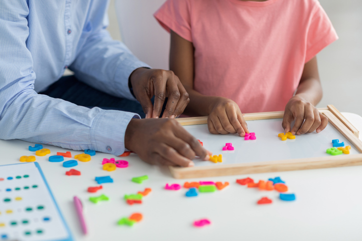 Cropped of african american teacher and pupil exercising with letters