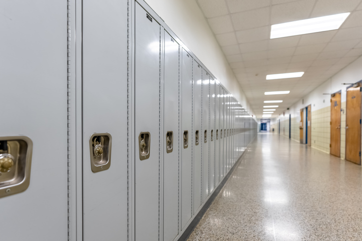 Empty middle school or high school hallway with gray student lockers