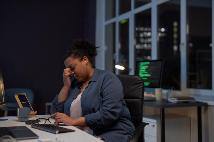 Exhausted woman working till late night in office