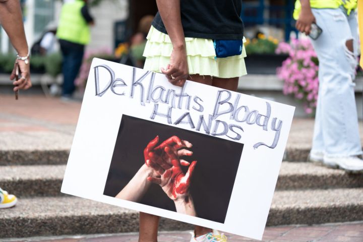 demonstrator holds a sign referencing Florida Gov. Ron Desantis