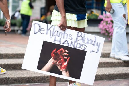 Demonstrator holds a sign referencing Florida Gov. Ron DeSantis.