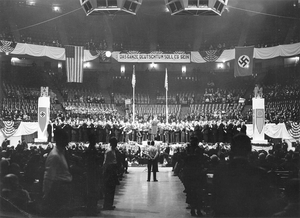 USA New York New York City: 'German Day' in the Madison Square Garden to commemorate the arrival of the first German settlers on U.S. territorry under banners with nationalist slogans and a Swastika as well as U.S flag - 1935 - Vintage property of ul