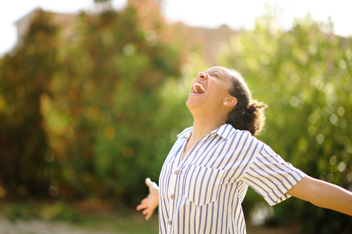 Excited black woman screaming in a park
