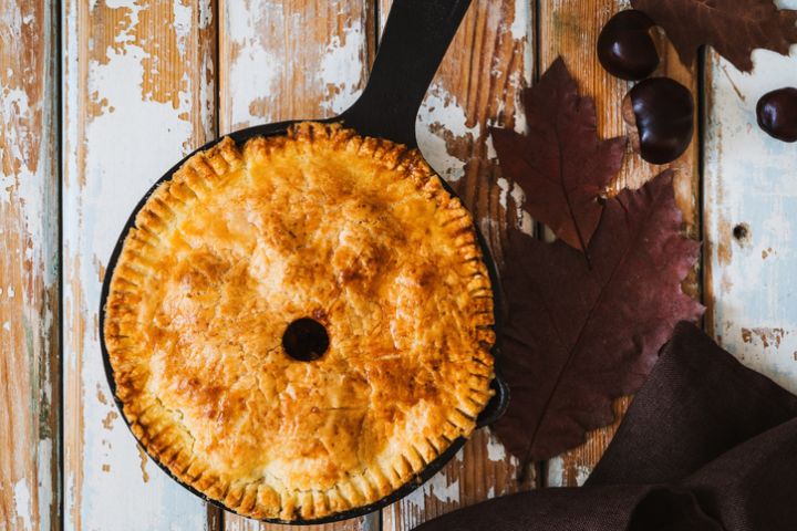 Homemade apple pie in cast iron skillet, traditional autumn and winter cozy dessert