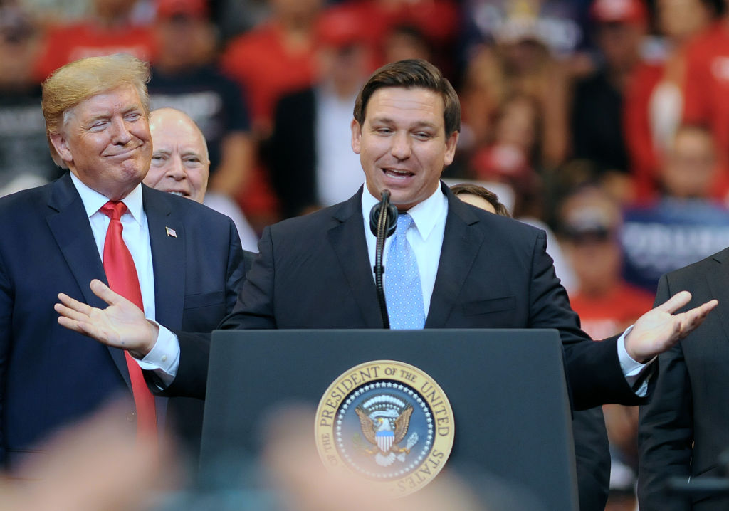 U.S. President Donald Trump looks on as Florida Governor Ron...