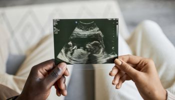 Close up of African American man and woman holding ultrasound picture together