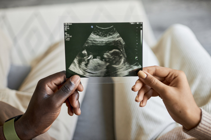 Close up of African American man and woman holding ultrasound picture together