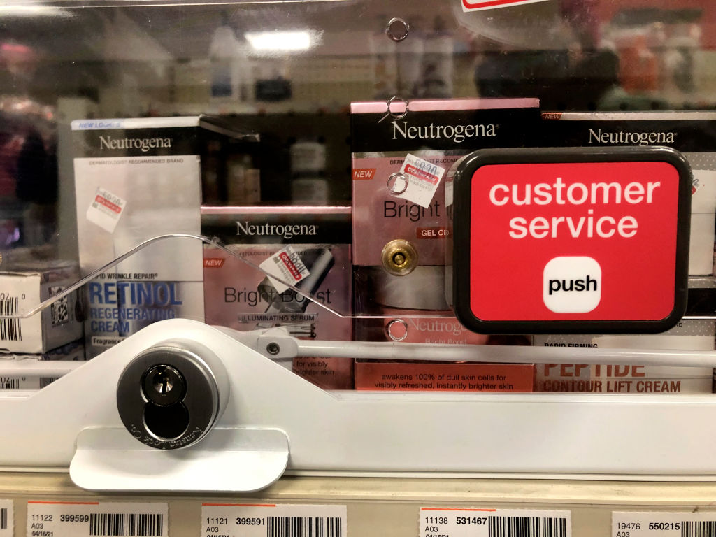 Anti-theft locked merchandise on shelves with customer service button at CVS pharmacy, Queens, New York