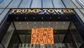 Participant seen holding a sign outside Trump Tower. In...