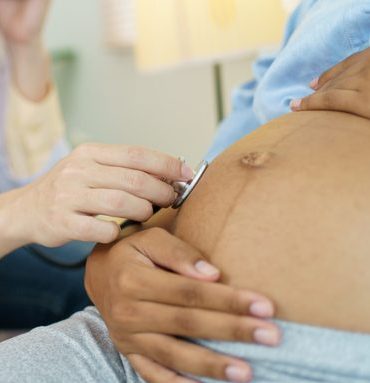 Pregnant woman talking to doctor.