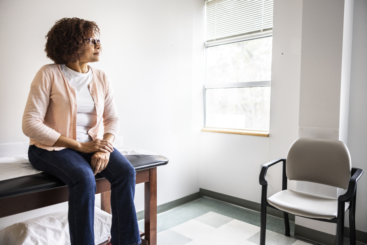 Senior woman waiting in in doctors exam room