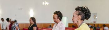 Church Members Standing in Prayerful Contemplation