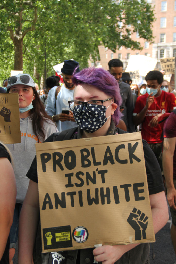 A protester holds a placard that says Pro black isn't Anti-...