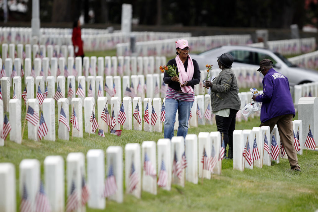LaDonna McTiller, left, Eve Purvis-Allen, center, and Dr. Robert Hollis, right, with the National Association of Black Veterans East Bay Chapter, make their way through the National Cemetary placing flowers on the graves of Buffalo Soldiers duruing Memori