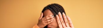 Young african american smart woman wearing glasses and casual sweater over yellow background covering eyes with hands and doing stop gesture with sad and fear expression. Embarrassed and negative concept.