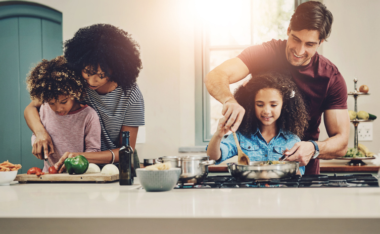 Family, meal prep and helping for cooking in kitchen with vegetables, teaching and nutrition salad of lunch food. Love, interracial parents and kids for learning vegan diet, healthy dinner and house