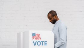 African american ethnicity citizen cast ballot at modern polling booth during a democratic election