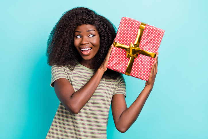 Photo of dreamy excited lady wear striped t-shirt guessing what inside gift box isolated turquoise color background