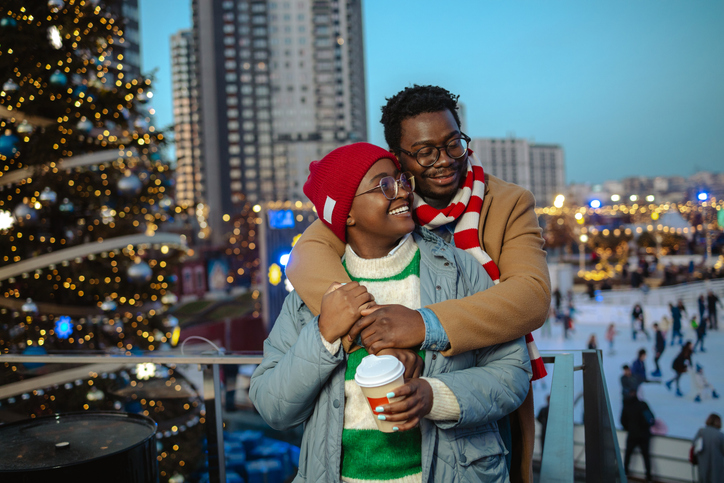Joyful African American couple enjoying a magical evening with festive lights outdoors