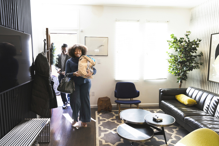 Mature couple carrying groceries into house
