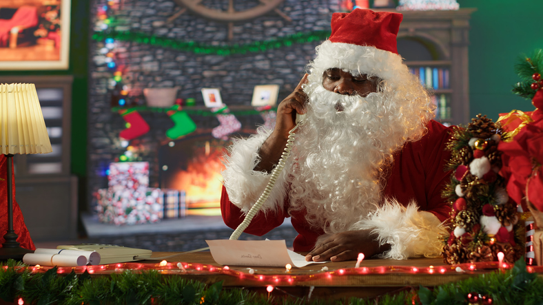 African american Saint Nick reading letters his rustic log cabin
