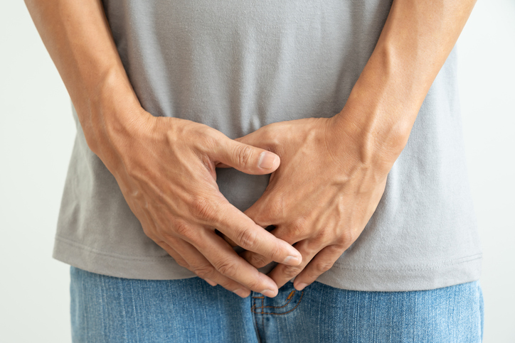 Man hold hand in front of private parts feeling discomfort from disease and inflammation. Venereal, testicular cancer. bladder problems, erectile dysfunction, premature ejaculation, prostate cancer, contraception